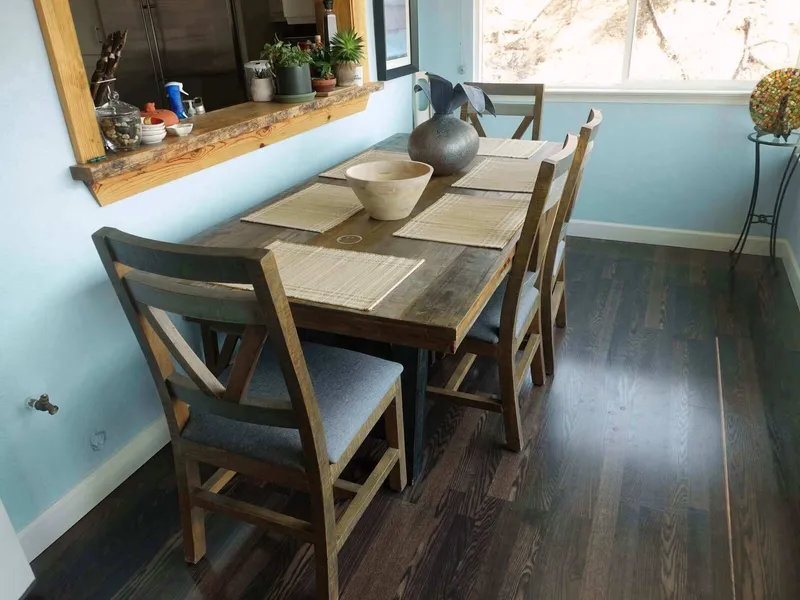 A dining table and chairs by the window at the residence