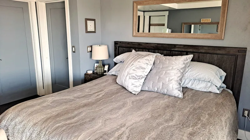 Private bedroom with soft bedding and a mirror